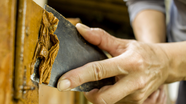 En person som skraper flekk av tre