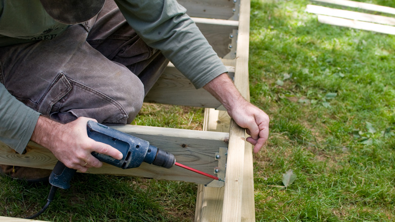 en person som borer hull i trelast