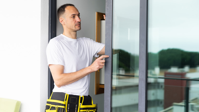 Mann som installerer skyvedører i glass