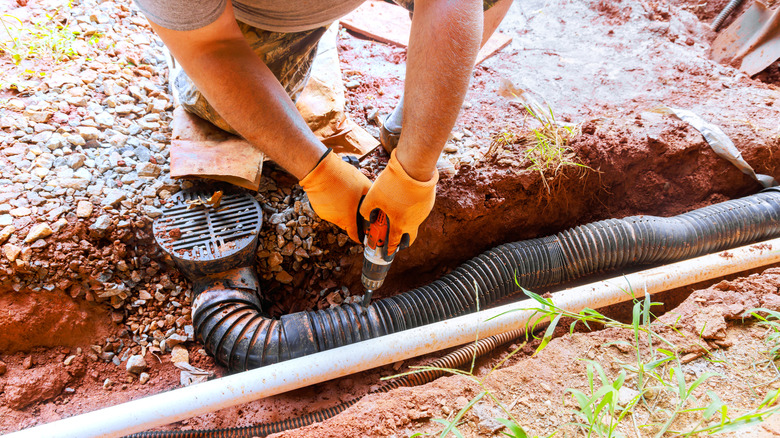 Entreprenør jobber med å fikse underjordisk rør i gården