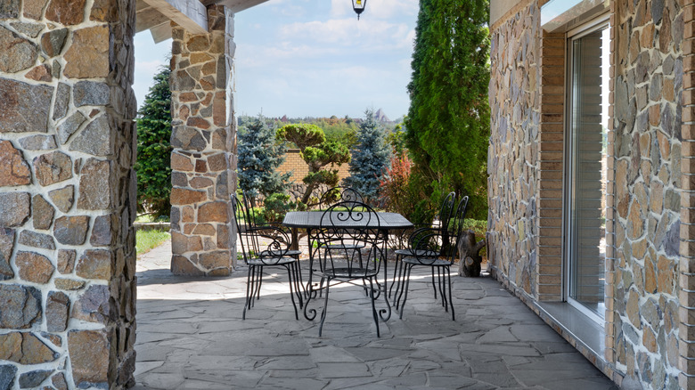 En overbygd steinveranda med spisestue