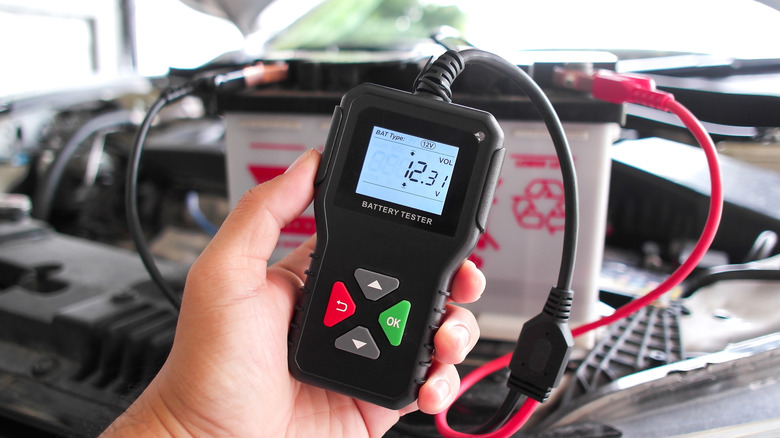 En digital batteritester viser en avlesning på 12,31V mens den er koblet til et 12V blybatteri.