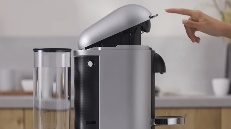 Person som rengjør en Nespresso kaffetrakter