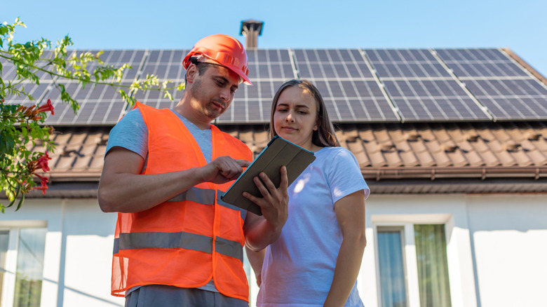 en ingeniør og kvinne som diskuterer installasjon av solcellepanel