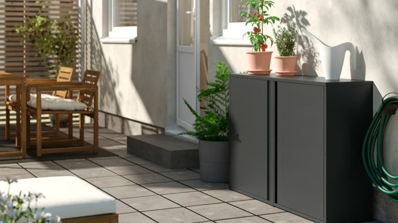 Uteplass med IKEA skap mot vegg med potteplanter på toppen