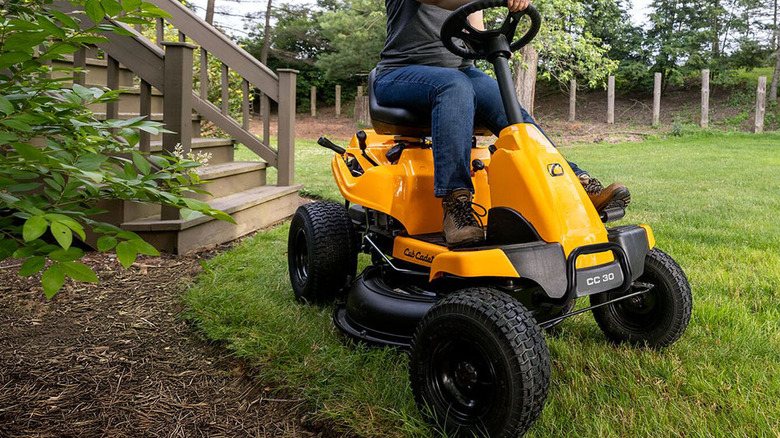 En person som bruker Cub Cadet CC30 H gressklipper med bakmotor